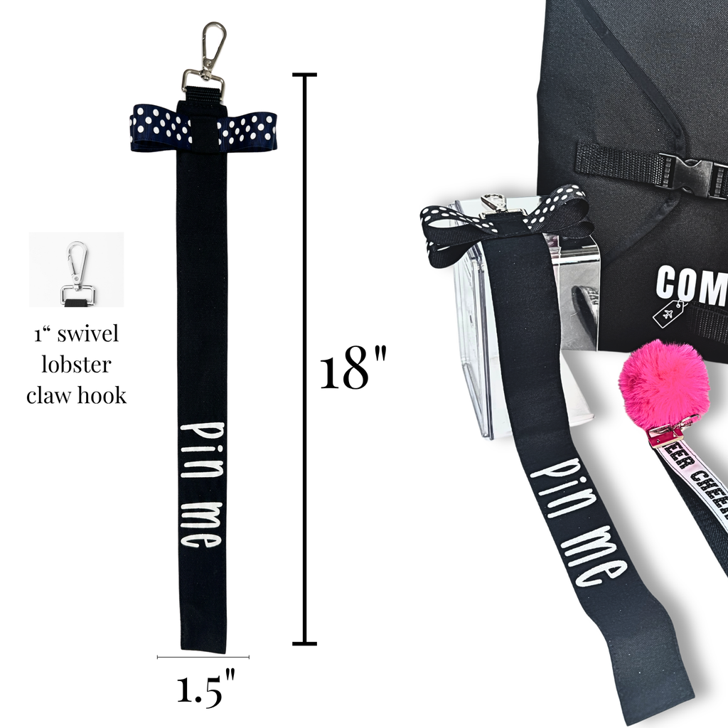 Black cotton cheer pin me ribbon with white text and polka dot bow, 18 inches long with swivel lobster claw hook.
