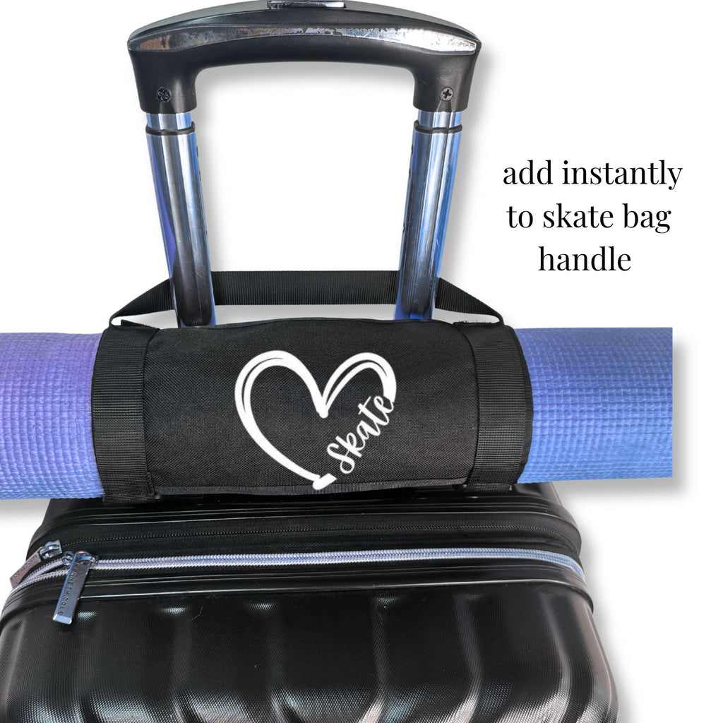 Black canvas mat holder attached to a luggage handle carrying a purple yoga mat with a white heart and skate design, ideal.
