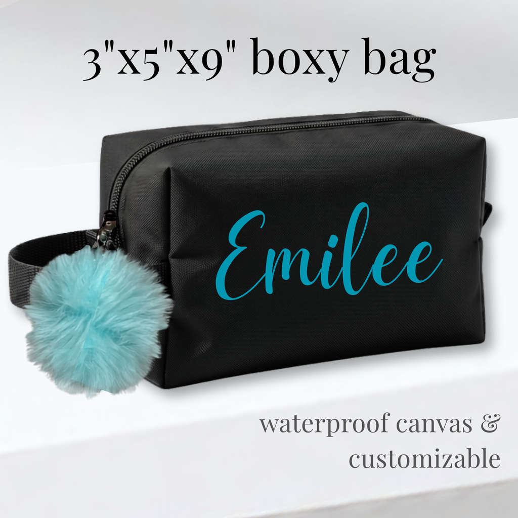 Black rectangular cheer and skate competition bag with customizable blue name and blue pom-pom charm.