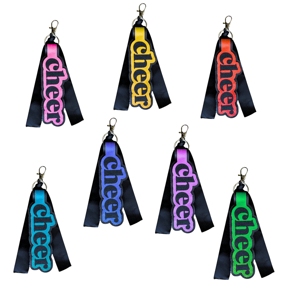 Set of six rectangular bag tags with bright "cheer" text in pink, yellow, red, blue, purple, and green on black straps, each