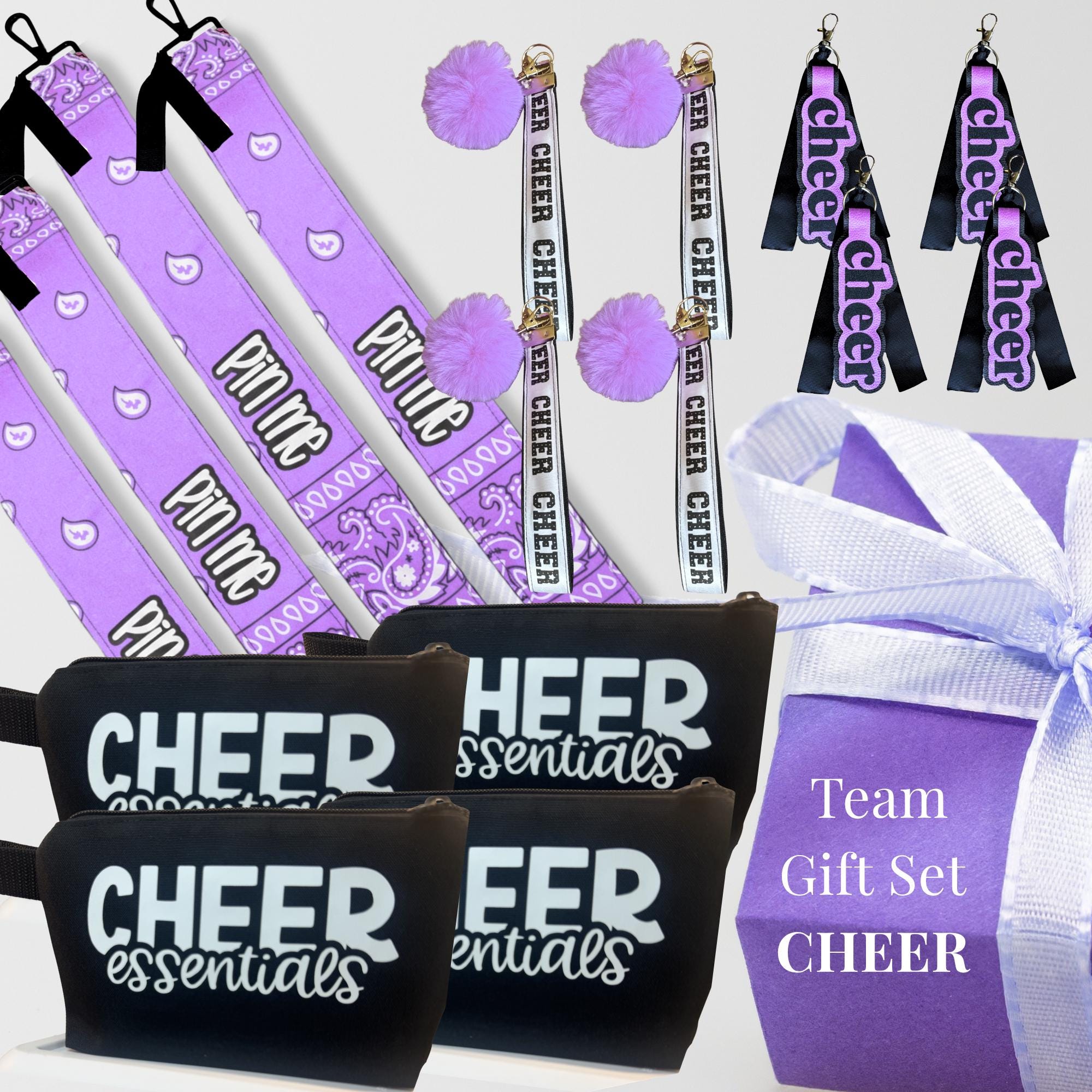 Purple cheer bag tags, black zippered pouches with "Cheer Essentials," and cheer-themed keychains with pom-poms and ribbons.