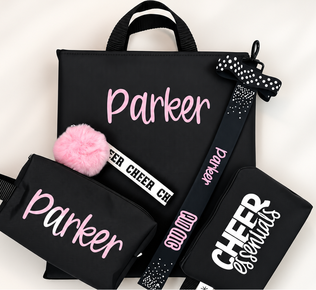 Black cheer backpack set with pink personalized name, pom pom keychain, bow hair tie, and cheer emergency kit pouch.
