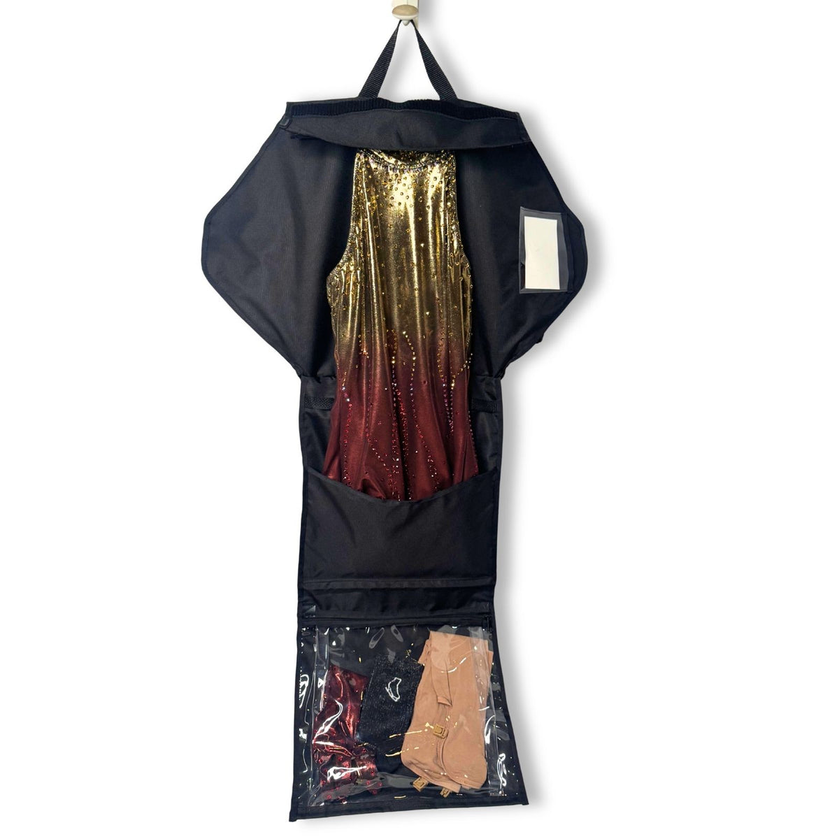 Black vertical skate bag with clear bottom compartment, open flap revealing red and gold glittery skate dress inside,.