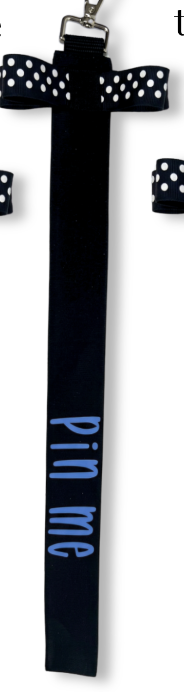 Black cotton cheer ribbon pin with white polka dots and light blue "pin me" text, designed for bags or uniforms.